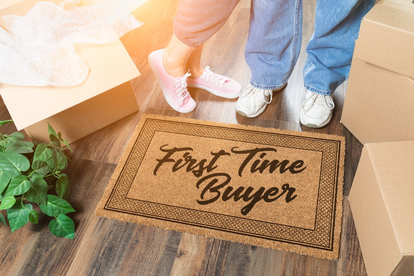 Man and Woman Unpacking Near Our First Time Buyer Welcome Mat, Moving Boxes and Plant